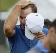  ?? DAVID J. PHILLIP — THE ASSOCIATED PRESS ?? Dustin Johnson wipes his head as he walks off the 18th green on Friday. Johnson missed the cut.