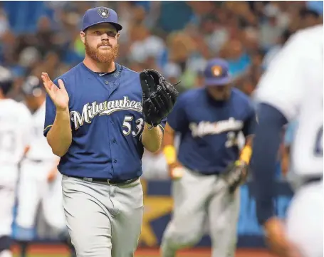  ?? / USA TODAY SPORTS ?? Brewers starter Brandon Woodruff walks back to the dugout triumphant­ly after pitching out of a bases-loaded jam in the first inning Friday night.