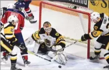  ?? PETER LEE, RECORD STAFF ?? Hamilton Bulldogs goalie Kaden Fulcher watches a loose puck as teammate Jack Hanley, right, prepares to gather it in.