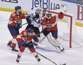  ?? PATRICK FARRELL pfarrell@miamiheral­d.com ?? Panthers goalie Roberto Luongo reaches for the puck in traffic in the first period of the Panthers’ 6-2 win against the Sharks. Luongo made 27 saves in the victory.