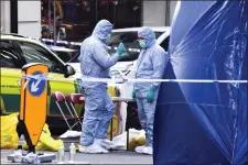  ?? ALBERTO PEZZALI - THE ASSOCIATED PRESS ?? Forensic workers attend the scene on London Bridge in London, Saturday, Nov. 30. UK counterter­rorism police on Saturday searched for clues into how a man imprisoned for terrorism offenses before his release last year managed to stab several people before being tackled by bystanders and shot dead by officers on London Bridge. Two people were killed and three wounded.