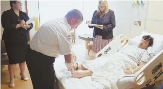  ?? HERALD POOL PHOTO ?? IN CUSTODY: An officer attaches cuffs to Douglas Dematos’ ankles while his attorney, Frances Dallmeyer, right, and Assistant District Attorney Ashlee Mastrangel­o, left, look on during his arraignmen­t at Lowell General Hospital yesterday.