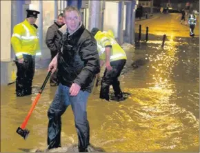  ??  ?? Ger Byrne from the Bridge Tavern trying desperatel­y to fight the flooding of his premises.