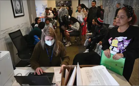  ?? HELEN H. RICHARDSON — THE DENVER POST ?? Volunteer Snezhanna Singleton, left, inputs informatio­n into a computer for Venezuelan migrant Carolina Gonzalez to help her begin the work permitting process at a local hotel in Denver on Feb. 5. Douglas County on Monday sued the state of Colorado over laws passed in recent years that prohibit local government­s in the state from cooperatin­g with the federal government in immigratio­n matters.