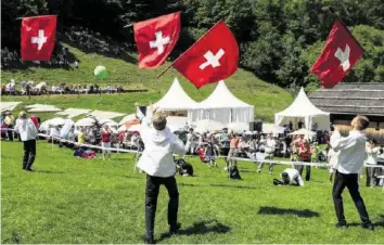  ?? KEYSTONE ?? Bringen Farbe in den Anlass: Fahnenschw­inger auf der Rütliwiese am 1. August 2017.