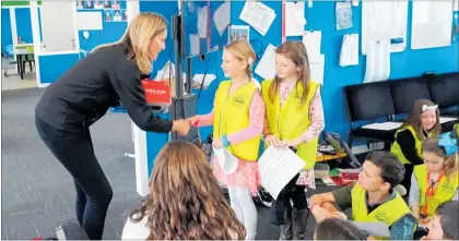  ??  ?? Canon New Zealand chief executive Kim Conner (left) presenting the Canon Oceania grant and products to Kids Greening Taupo¯ ranger Kaiah Bosshart at Waipa¯ hı¯hı¯ School.