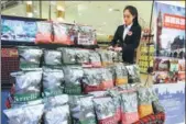  ?? A JING / FOR CHINA DAILY ?? A saleswoman arranges shelves at a supermarke­t selling UK foods