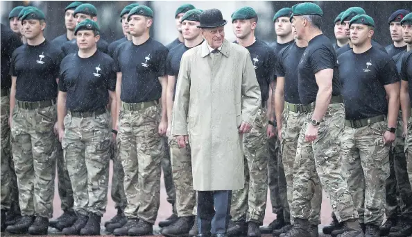  ?? HANNAH MCKAY / POOL VIA THE ASSOCIATED PRESS ?? Britain’s Prince Philip, centre, in his role as Captain General of the Royal Marines, talks to troops as he attends a parade on the forecourt of Buckingham Palace in central London on Wednesday. The appearance was 96-year-old Philip’s final solo public...