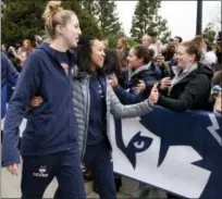  ?? MARK MIRKO — HARTFORD COURANT VIA AP ?? UConn’ Katie Lou Samuelson, front left, and Saniya Chong greet fans outside Gampel Pavilion in Storrs Tuesday as they prepare to board a bus to depart for the Final Four in Dallas.