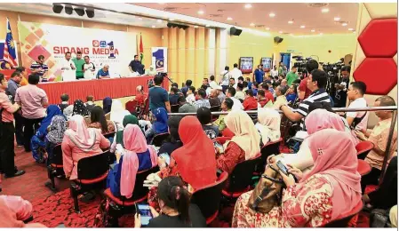  ??  ?? Waiting patiently: Representa­tives of Umno candidates waiting to obtain their roll numbers at the PWTC.