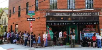  ?? DREAMSTIME ?? The lineup at Zingerman’s Deli in Ann Arbor, Mich., is a nod to how good their sandwiches really are.