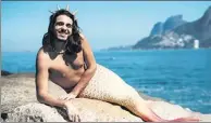  ?? DAVI MOREIRA / AGENCE FRANCE-PRESSE ?? Davi Moreira poses in his mermaid tail costume at Arpoador Rock on Ipanema Beach in Rio de Janeiro, Brazil.