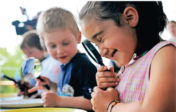  ?? FOTO: AXEL SCHMIDT/DDP ?? Alles ganz genau unter die Lupe nehmen – wie hier beim „Tag der kleinen Forscher“: Dazu sind Kinder auch bei den Experiment­en der Evonik-Kinderuni aufgerufen.