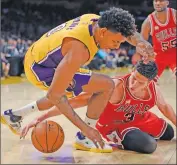  ??  ?? Los Angeles Lakers forward Nick Young, left, and Chicago Bulls forward Doug McDermott fight for the ball during the first half on Thursday in Los Angeles.