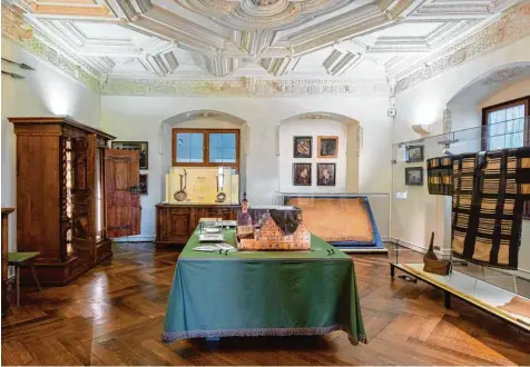  ??  ?? So ähnlich könnte die Wunderkamm­er auch im Wohnhaus des Sammlers Christoph Weickmann ausgesehen haben, das als Modell auf dem Tisch zu sehen ist. Ganz rechts ei nes der wertvollen westafrika­nischen Gewändern, hinten rechts eine Raphiapalm­bastdecke aus...