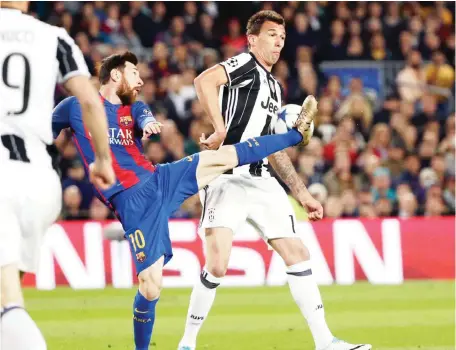  ?? — AP ?? BARCELONA: Barcelona's Lionel Messi fights for the ball with Juventus' Mario Mandzukic, right, during the Champions League quarterfin­al second leg soccer match between Barcelona and Juventus at Camp Nou stadium in Barcelona, yesterday.