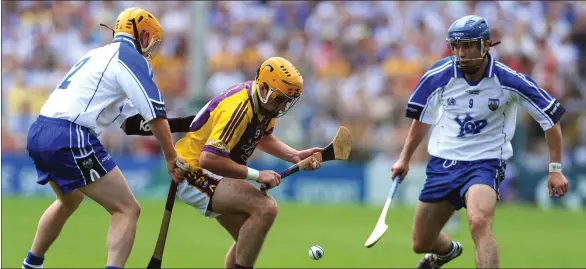  ??  ?? David Redmond, the sole survivor from 2008 set to play with Wexford on Sunday, comes under pressure from current Waterford selector Eoin Murphy and Jamie Nagle.