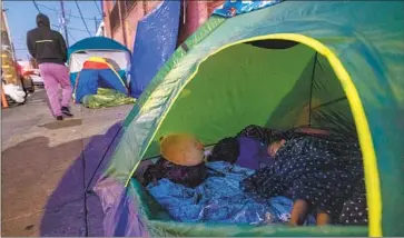  ?? Brian van der Brug Los Angeles Times ?? A CHILD SLEEPS in a Skid Row encampment in Los Angeles, where “each and every homelessne­ss assistance program and initiative” funded or run by the city will be scrutinize­d in an audit ordered by a federal judge.