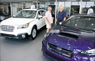  ?? Lake Fong/Post-Gazette ?? Sales consultant J.D. Brown, right, of Kenny Ross Subaru talks with Harry Franey of Normalvill­e at the dealership's showroom in North Huntingdon on July 27.