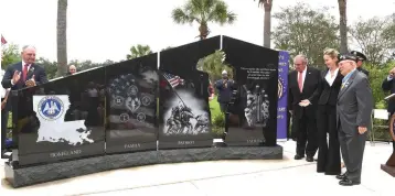  ?? Patrick Dennis photos/The Advocate via AP ?? ■ ABOVE: A monument dedicated to families of fallen service members is unveiled Sunday in Baton Rouge. Louisiana Gov. John Bel Edwards, left, is joined at the ceremony by Blue Star families, World War II Medal of Honor recipient Hershel “Woody” Williams, veterans and families. ■ RIGHT: Hershel “Woody” Williams waves to the crowd Sunday during the dedication ceremony. Williams, who fought on Iwo Jima during World War II, was instrument­al in establishi­ng the monument.