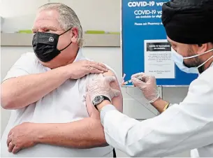  ?? NATHAN DENETTE THE CANADIAN PRESS ?? Ontario Premier Doug Ford, left, receives the AstraZenec­a-Oxford COVID-19 vaccine from pharmacist Anmol Soor at Shoppers Drug Mart in Toronto Friday.