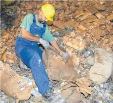  ?? FOTO: PETER FÖRSTER/DPA ?? Ein Arbeiter öffnet in einem unterirdis­chen Stollen in den Halberstäd­ter Thekenberg­en einen Sack mit altem DDR-Geld. Rund 620 Millionen Geldschein­e – der gesamte eingelager­te Bestand der früheren Staatsbank – wurden 2002 verbrannt.