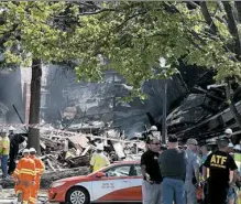  ?? T.J. Kirkpatric­k/Getty Images ?? Fire and rescue crews and investigat­ors examine the site of an explosion and fire that destroyed an apartment building Thursday in Silver Spring, Md.