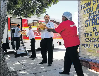  ?? Picture: WERNER HILLS ?? HELPING HANDS: Shoprite regional manager Les Ferreira, middle, helps staff to offload the parcels