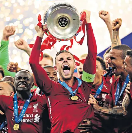  ??  ?? Leader: Jordan Henderson raises the Champions League trophy