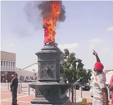  ??  ?? TWITTER Members of a radical South African movement set fire to a monument to British soldiers who died in the Boer Wars Thursday in Uitenhage.