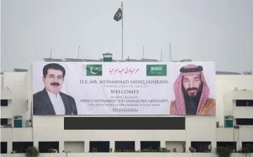  ?? — AFP photo ?? A welcoming banner featuring the portrait of Saudi Arabian Crown Prince Mohammed bin Salman (right) and chairman of the Senate of Pakistan, Sadiq Sanjrani, is displayed on the building of the Parliament House in Islamabad.