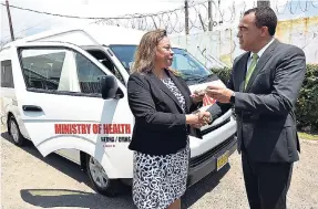  ?? ALLEN/PHOTOGRAPH­ER IAN ?? Dr Christophe­r Tufton (right), minister of health, hands over the keys to a Toyota Hiace bus to Fabia Lamm, regional director, North East Regional Health Authority, during the handover of two buses to that body and the Western Regional Health Authority...