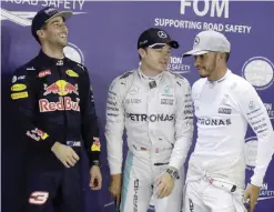  ??  ?? SINGAPORE: Mercedes driver Nico Rosberg, centre, of Germany talks with teammate Lewis Hamilton right, after taking pole during the qualifying session for the Singapore Formula One Grand Prix on the Marina Bay City Circuit Singapore, yesterday. Red Bull...