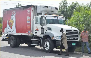  ?? JERMAINE BARNABY ?? Crime scene detectives process a truck in Christian Gardens, Portmore, yesterday. The truck was believed to have had two dead bodies inside. It was later revealed that no one had died but gunmen had hijacked the vehicle and stole 160 cases of chicken...