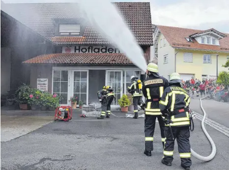  ?? FOTO: BRIGITTE WALTERS ?? Wasser marsch: Bei der Jahreshaup­tübung der Abteilung Ittendorf der Freiwillig­en Feuerwehr Markdorf rückt die Wehr zum Obsthof Marquart aus und muss einen fiktiven Schwelbran­d im Büro unter Kontrolle bekommen.