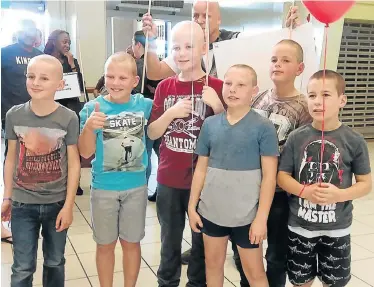  ??  ?? AT LAST: Trystin Stevens, centre, in red T-shirt, receives a warm welcome home from his friends