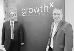  ??  ?? Ganesh (left) poses with Tan in front of the GrowthX Academy banner.