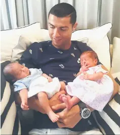  ??  ?? This picture obtained on Portugal captain Cristiano Ronaldo’s Facebook page shows Ronaldo carrying his new born twin daughters. — AFP photo