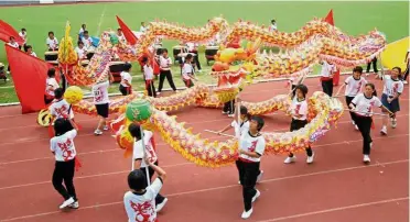  ??  ?? Students taking part in the dragon dance during the school’s sports day.