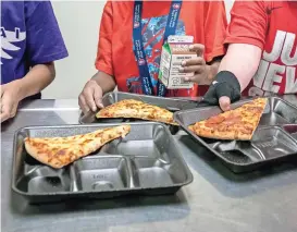  ?? ?? Estudiante­s de segundo grado selecciona­n sus alimentos durante el almuerzo en la escuela primaria en Scottsdale, Arizona