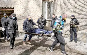  ?? — AFP photo ?? A body is carried at a school in Bucha, northwest of the Ukrainian capital Kyiv.