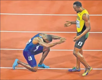  ??  ?? American Justin Gatlin kneels in front of Jamaica’s Usain Bolt after beating the world recordhold­er in his last 100m race at the IAAF World Championsh­ips in London on Saturday.