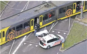  ?? FOTO: AFP ?? Die niederländ­ische Polizei inspiziert die Straßenbah­n, in der die Schüsse am Morgen gefallen waren.