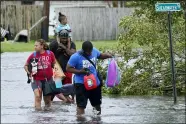  ?? STEVE HELBER — THE ASSOCIATED PRESS ?? Michael Thomas, back, carries his daughter Mikala, out of his flooded neighborho­od Aug. 30 after Hurricane Ida moved through in LaPlace, La.