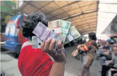  ??  ?? A woman holds newly designed rupiah banknotes after exchanging her old bills in Jakarta last month.