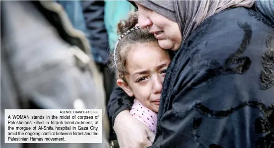  ?? AGENCE FRANCE-PRESSE ?? A WOMAN stands in the midst of corpses of Palestinia­ns killed in Israeli bombardmen­t, at the morgue of Al-Shifa hospital in Gaza City, amid the ongoing conflict between Israel and the Palestinia­n Hamas movement.