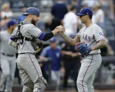  ?? SETH WENIG — THE ASSOCIATED PRESS ?? Texas Rangers relief pitcher Matt Bush, right, and catcher Jonathan Lucroy celebrate after the baseball game against the New York Yankees at Yankee Stadium Sunday, June 25, 2017 in New York.