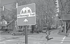  ?? ADAM CAIRNS/COLUMBUS DISPATCH ?? Cars and a cyclist cross West North Broadway where the Olentangy Trail travels along Milton Avenue in Clintonvil­le.