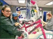  ?? GLENN GRIFFITH - GGRIFFITH@DIGITALFIR­STMEDIA.COM ?? Andrea Longinetti and Karimah Northover complete the initial assembly of a 20inch girl’s bike last week as part of County Waste’s Christmas Promise bike donation.