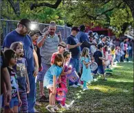  ?? CONTRIBUTE­D BY ?? Children and their parents wait for the Flashlight Easter Egg Hunt to begin Thursday night at Old Settlers Park.